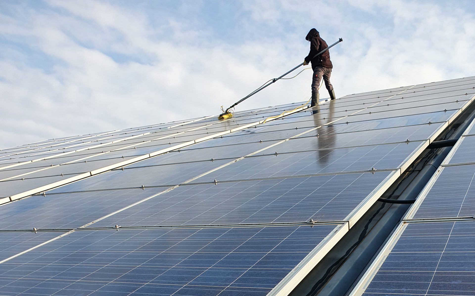 Mann reinigt Solaranlage
